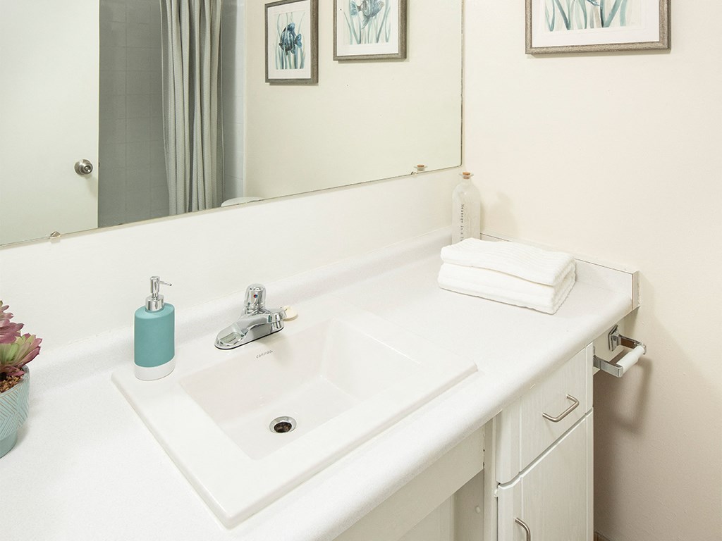 a white bathroom with a sink and a mirror
