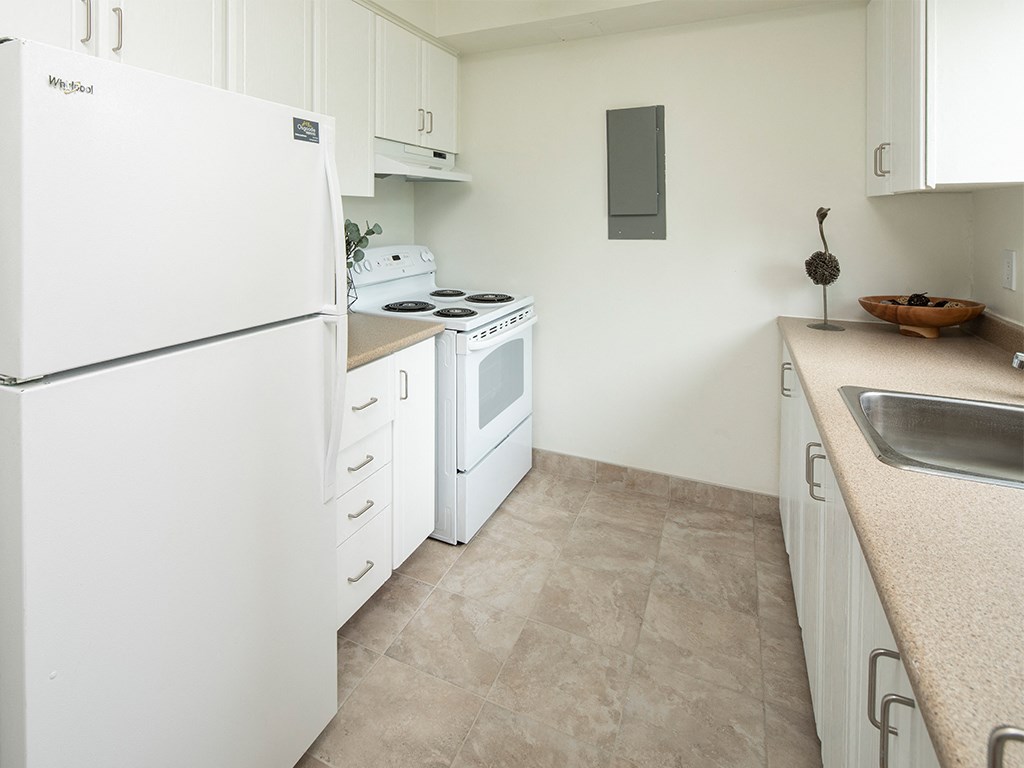 a kitchen with white appliances and a sink and a refrigerator