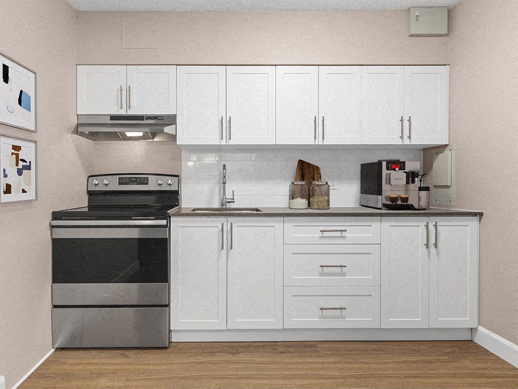a kitchen with white cabinets and a stove and a microwave
