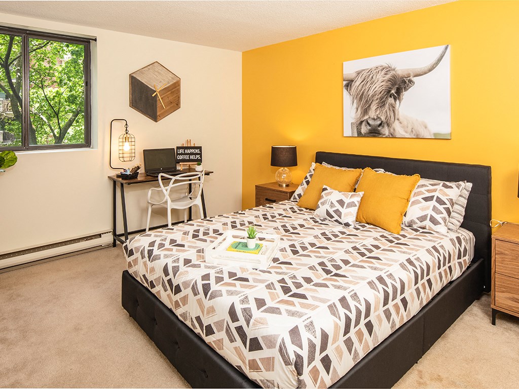 a bedroom with a bed and a bull painting on the wall