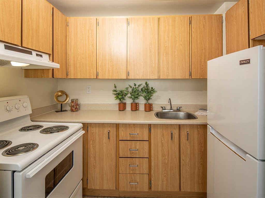 a kitchen with white appliances and wooden cabinets