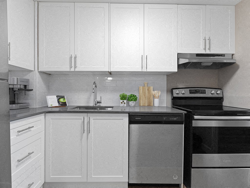 a white kitchen with stainless steel appliances and white cabinets