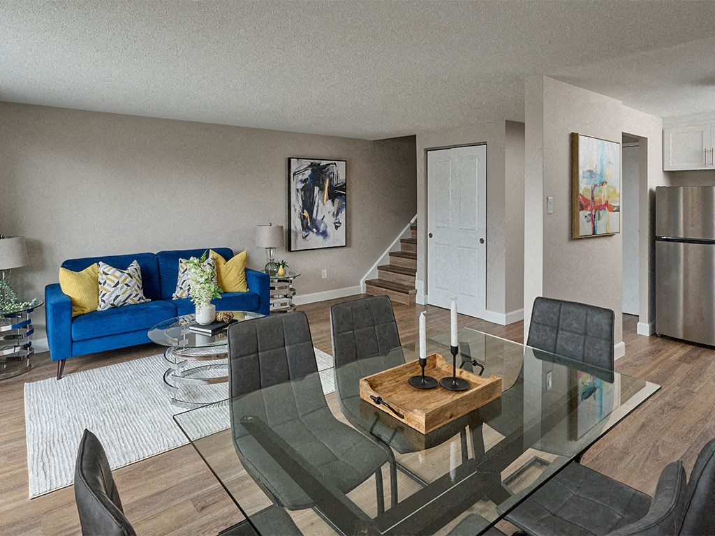 a living room with a glass table and a blue couch