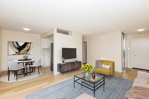 A modern living room with a dining table and a yellow sofa.
