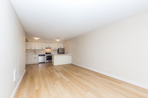 A kitchen with white cabinets and a wooden floor.