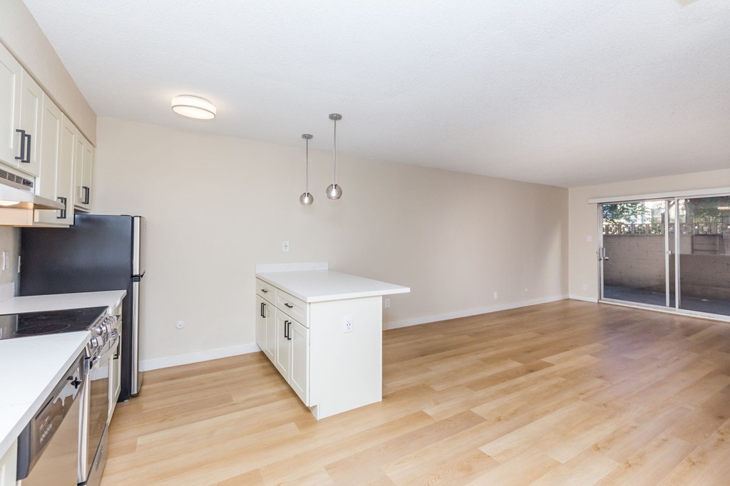 A kitchen with a black fridge and white countertops.