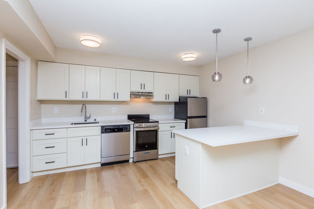 A kitchen with white cabinets and appliances.