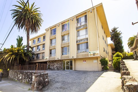 A yellow building with a stone wall in front.
