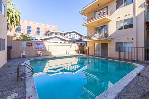 A swimming pool in a courtyard surrounded by buildings.