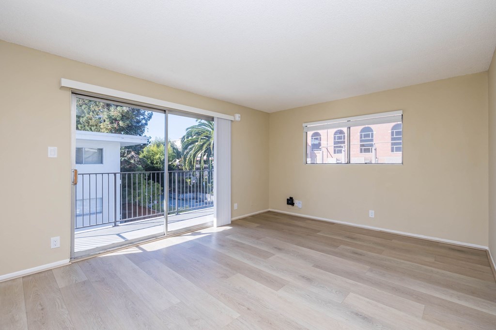 A room with a sliding glass door leading to a balcony.