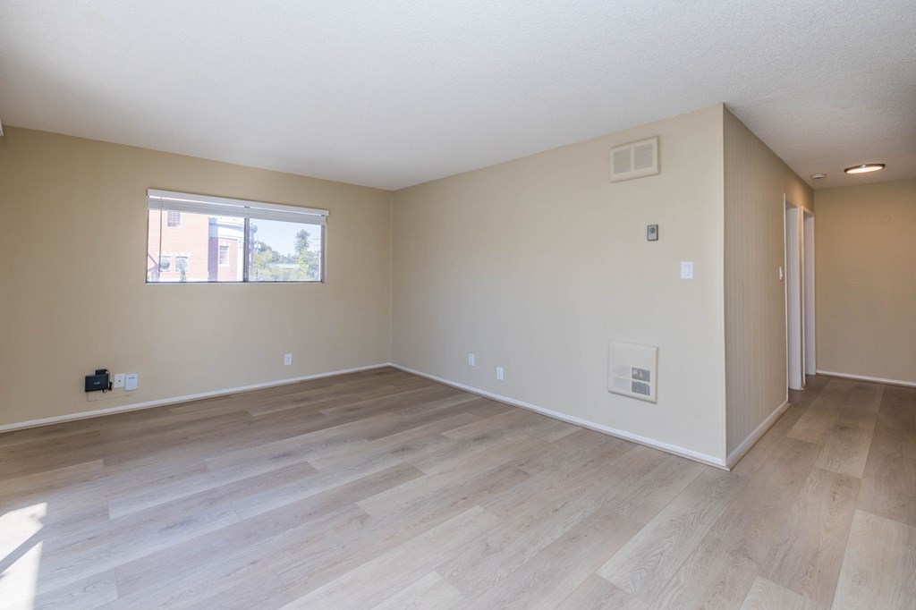 A room with wooden flooring and a window.