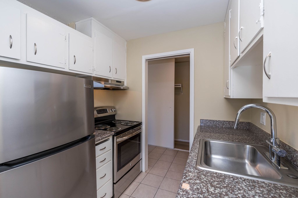A kitchen with a stainless steel refrigerator, oven, and microwave.