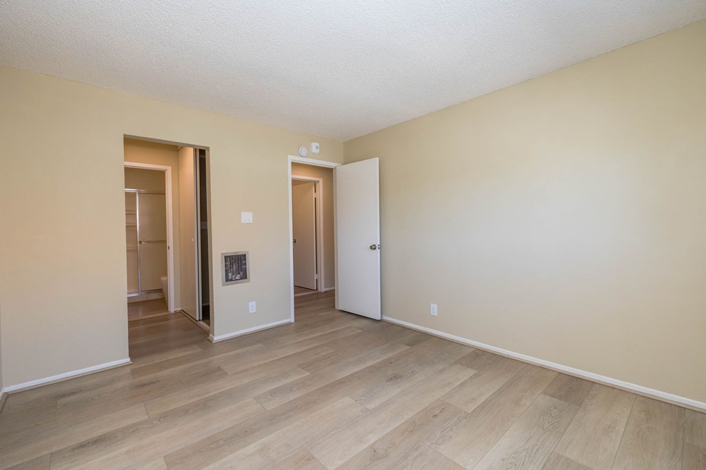 A room with a wooden floor and two doors.