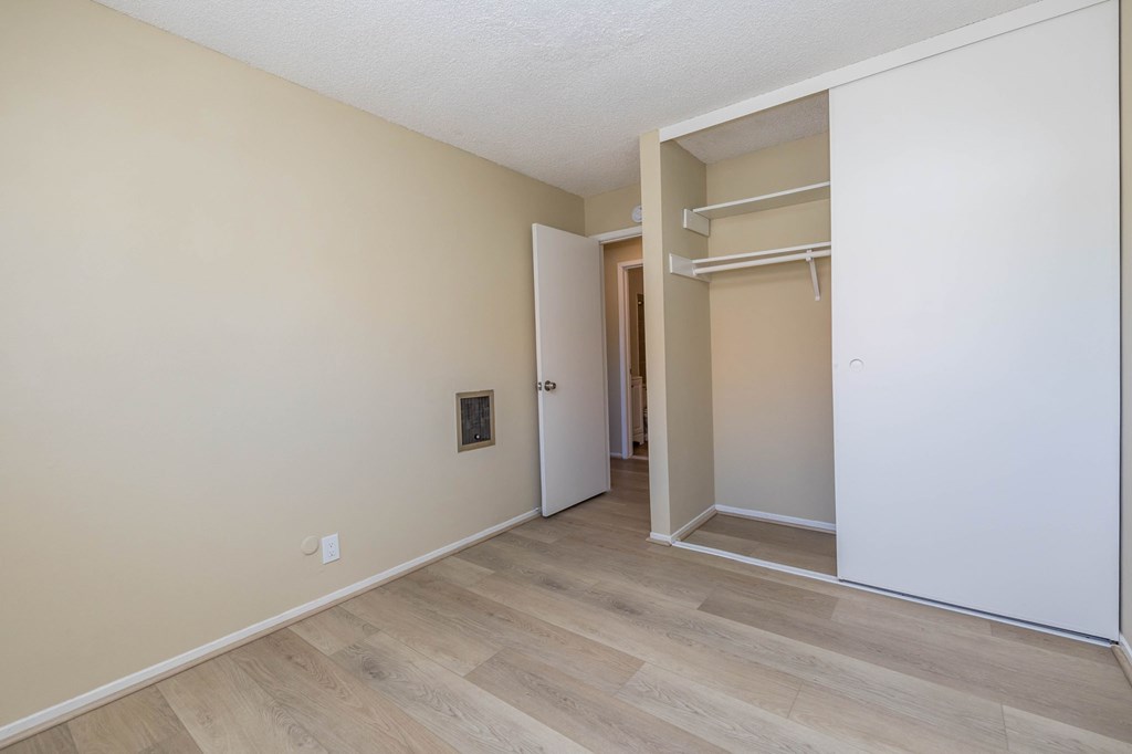 A room with a white door and a white closet with a white door.