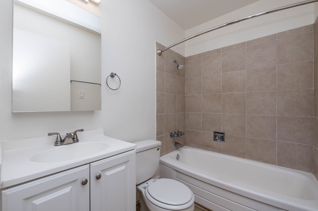 A bathroom with a white toilet, sink, and bathtub.