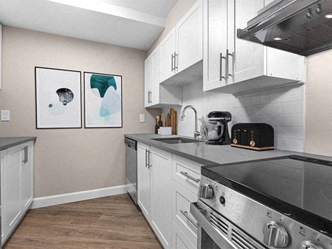 a kitchen with white cabinets and stainless steel appliances and a stove