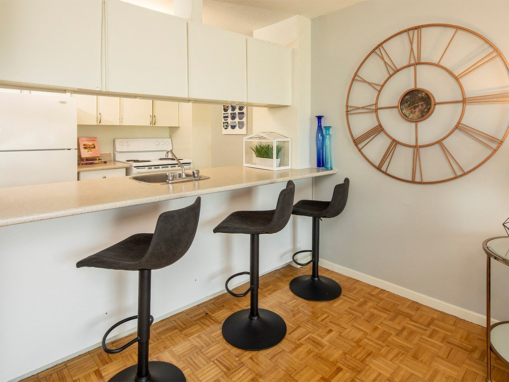 a kitchen with a counter and a large clock on the wall