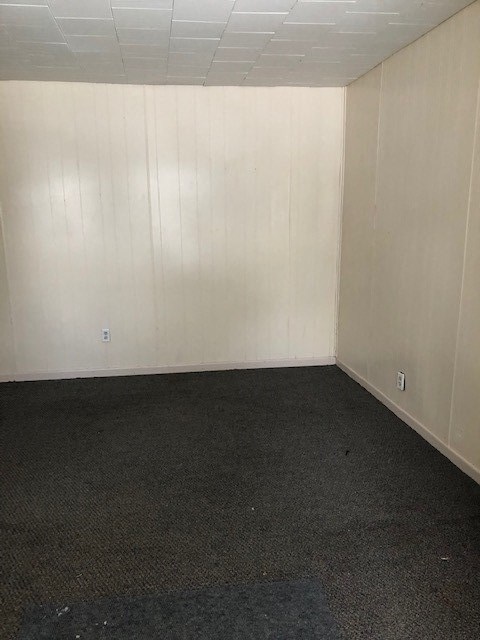 an empty room with a black floor and white walls