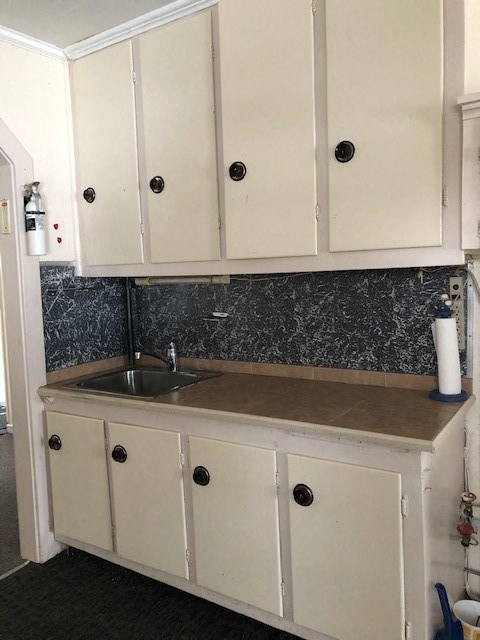 a kitchen with white cabinets and a sink