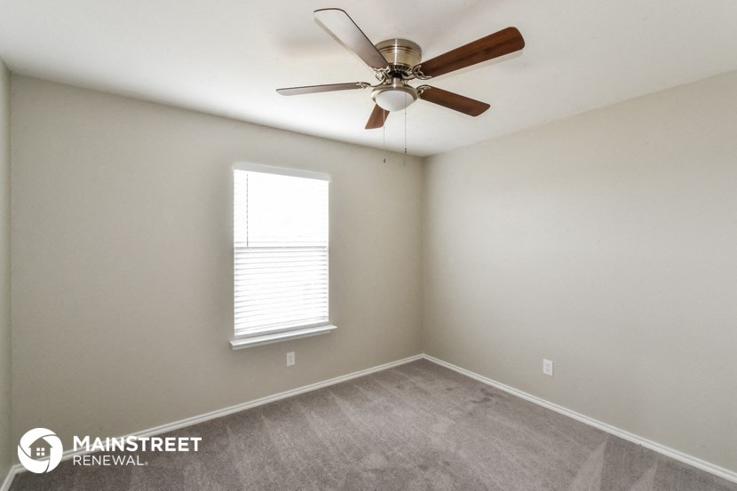 a bedroom with a ceiling fan and a window