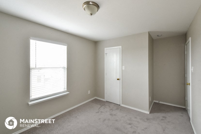 the living room of an apartment with a window and a door