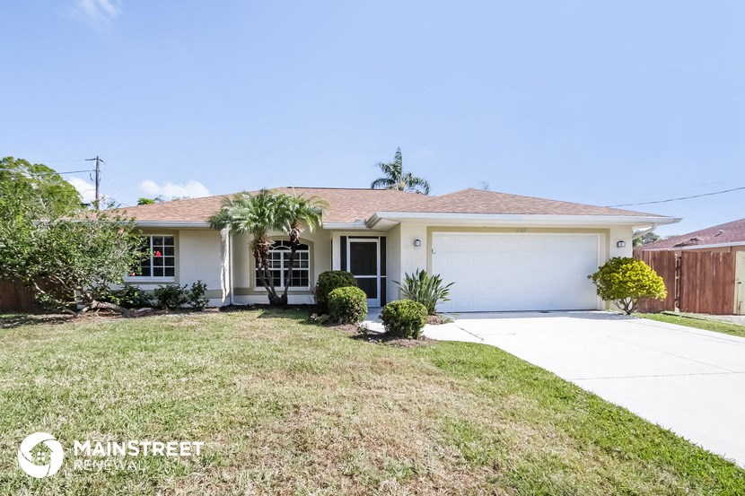a home with a lawn and a white garage door