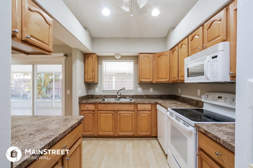 a kitchen with wooden cabinets and white appliances and granite counter tops