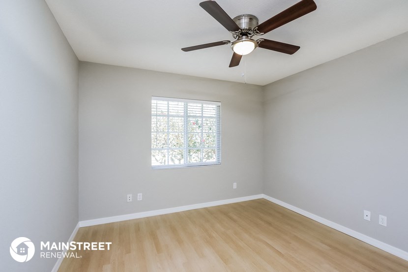 the master bedroom has a ceiling fan and hardwood floors