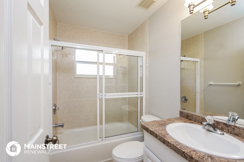 a bathroom with a shower and a sink and a toilet