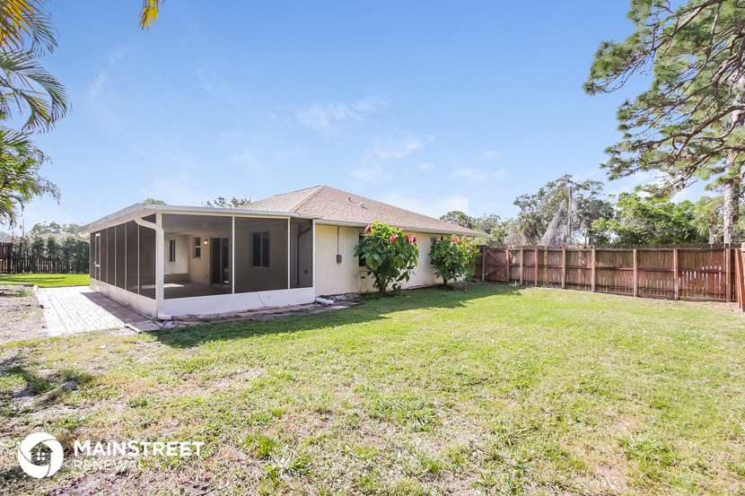 a backyard with a house and a yard and a fence