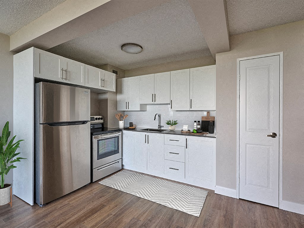 spacious kitchen with stainless steel appliances and white cabinets  the enclave apartments