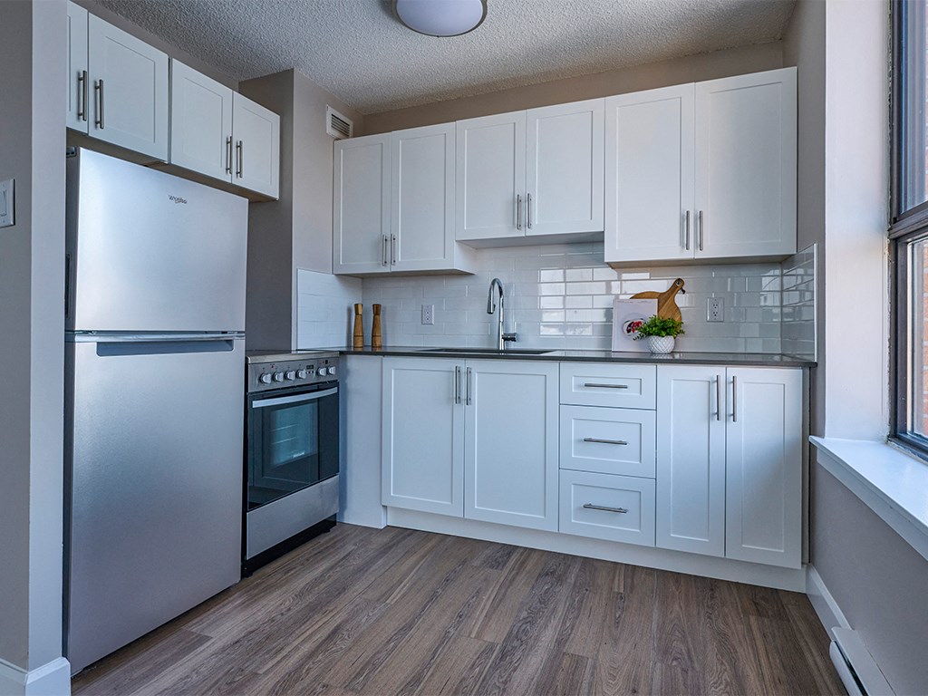 a kitchen with white cabinets and stainless steel appliances
