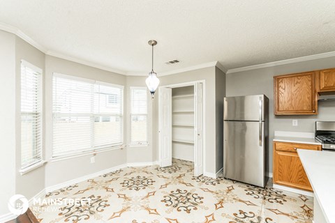 a kitchen with a stainless steel refrigerator and a large window