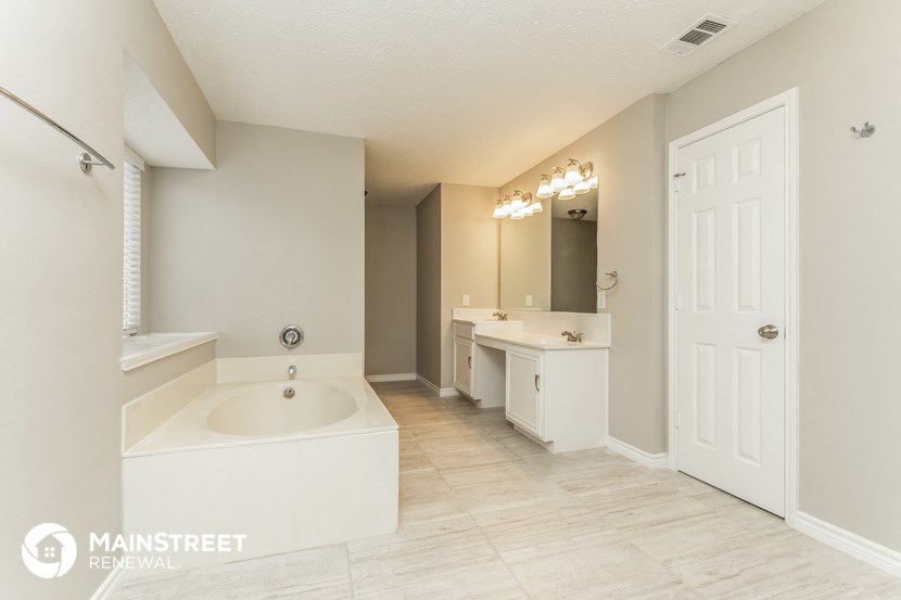 a bathroom with a tub and a sink and a mirror