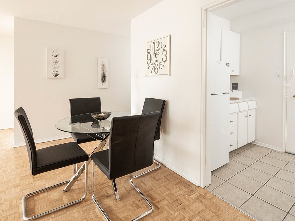a dining room with a glass table and chairs