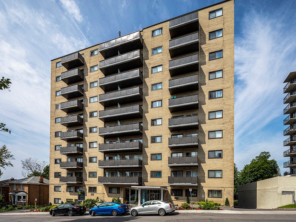 a tall apartment building with cars parked in front of it