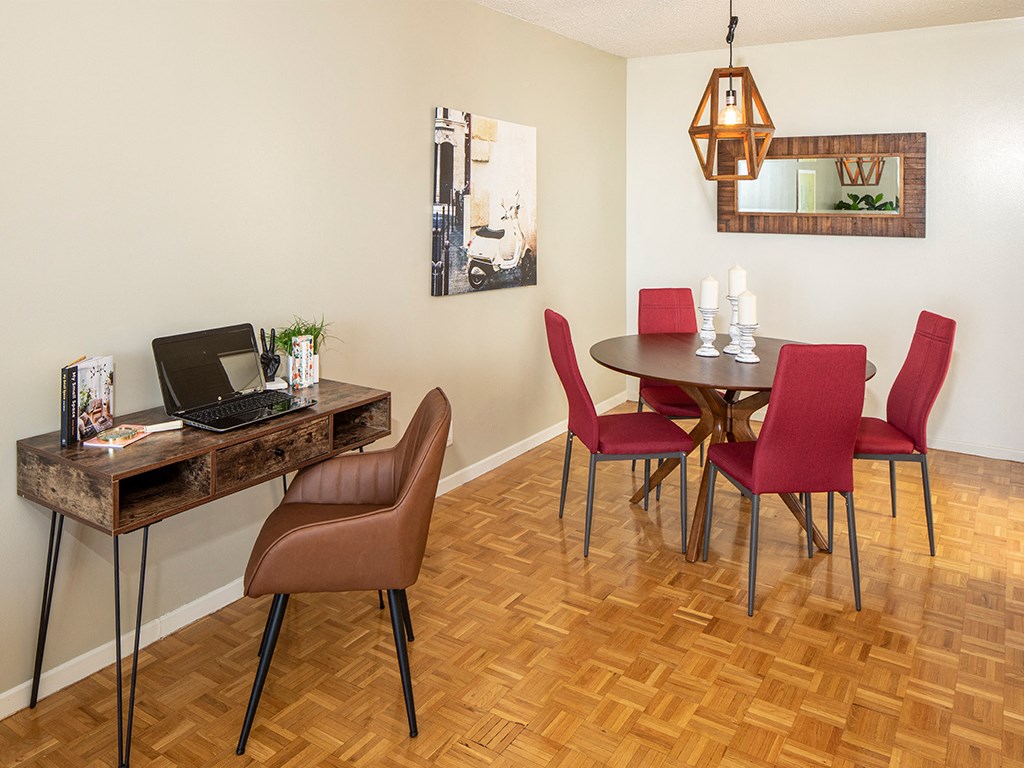 a dining room with a table and chairs and a laptop