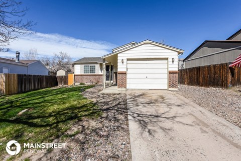a white garage with a driveway and a white house