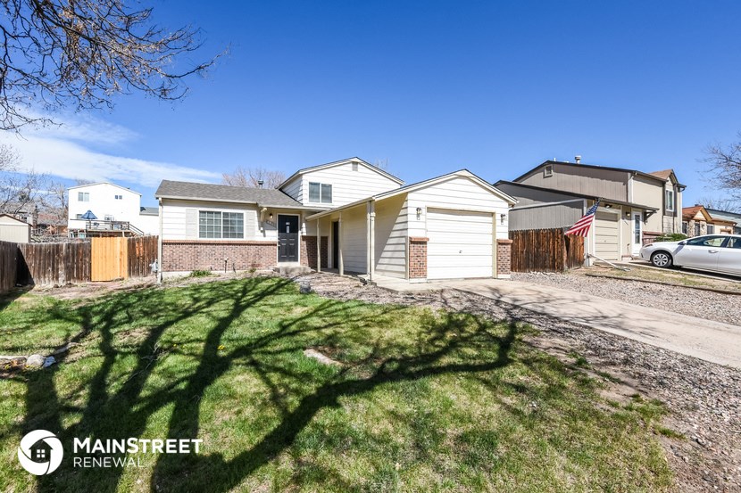 a house with a driveway and a yard in front of it