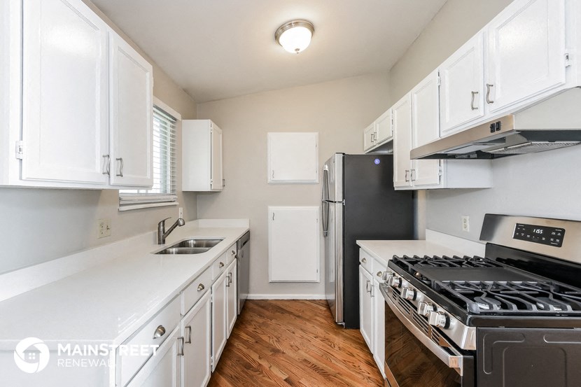 a kitchen with white cabinets and stainless steel appliances and a stove and refrigerator
