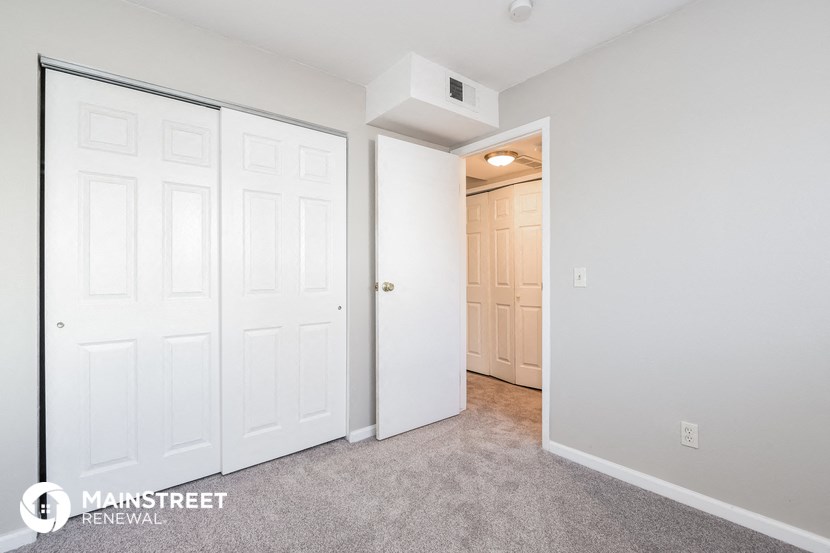 a bedroom with two closets and a door to a hallway