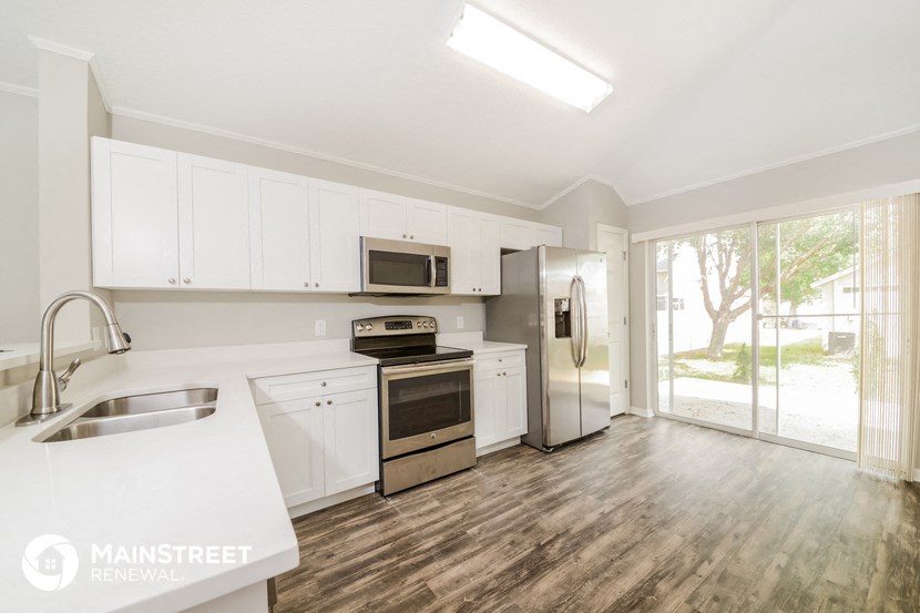 a kitchen with white cabinets and stainless steel appliances and a window