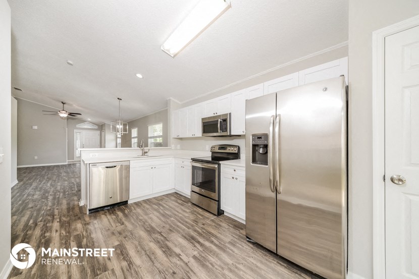 a large kitchen with stainless steel appliances and white cabinets