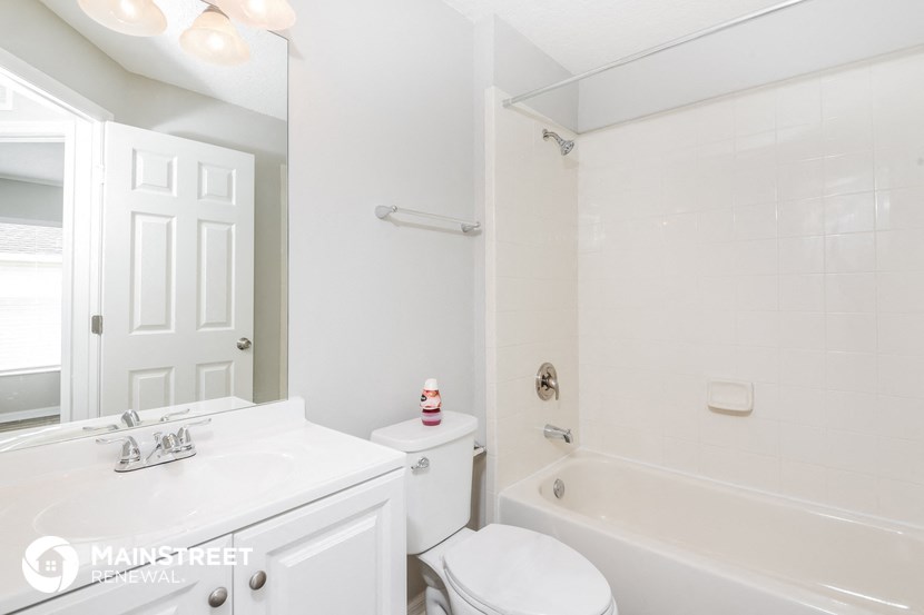 a white bathroom with a tub and a sink and a toilet