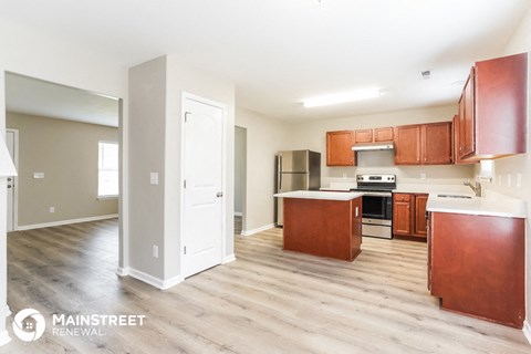 an open kitchen with wood floors and wooden cabinets