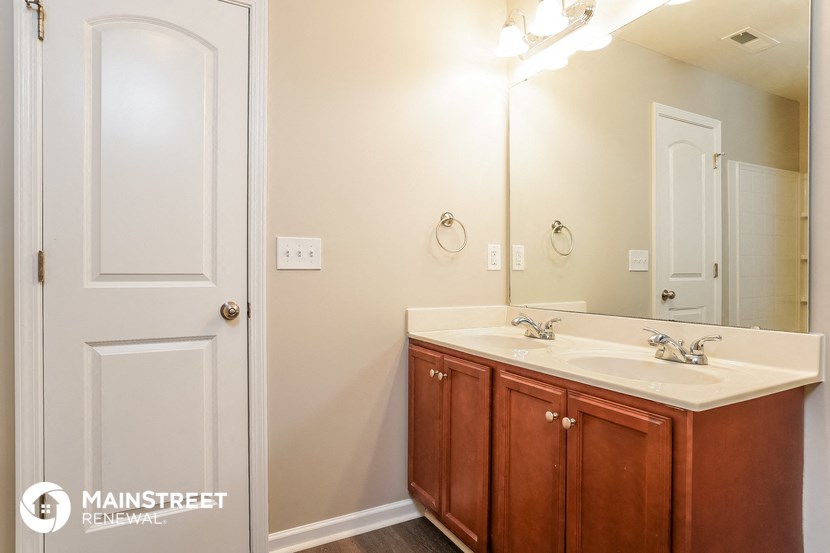 a bathroom with a sink and a mirror and a door