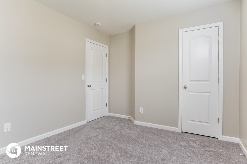a bedroom with two white doors and a carpeted floor