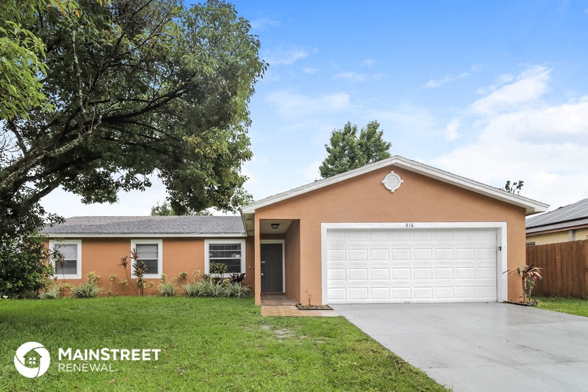 a home with a white garage door and a lawn