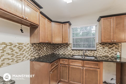 a kitchen with wooden cabinets and a sink and a window