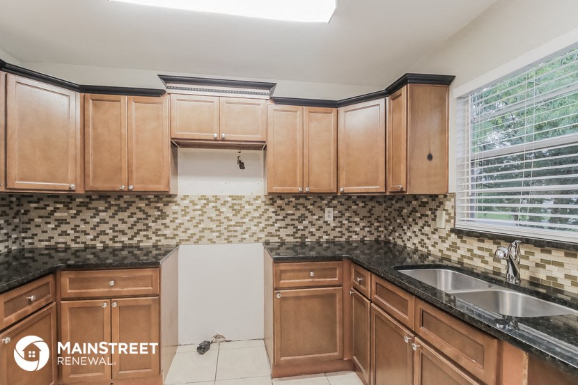 a kitchen with wooden cabinets and a sink and a window